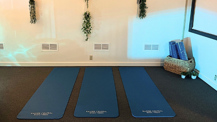 Yoga mats are shown on the floor for student use.