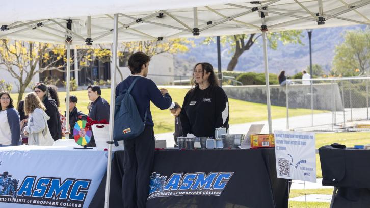 ASMC Director of Student Organizations Nora Barakat talks to a student during Club Rush 2024.